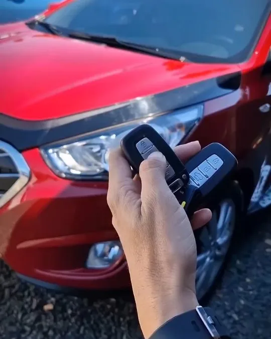 La llave de un Hyundai rojo en la mano, en la playa de Ghala